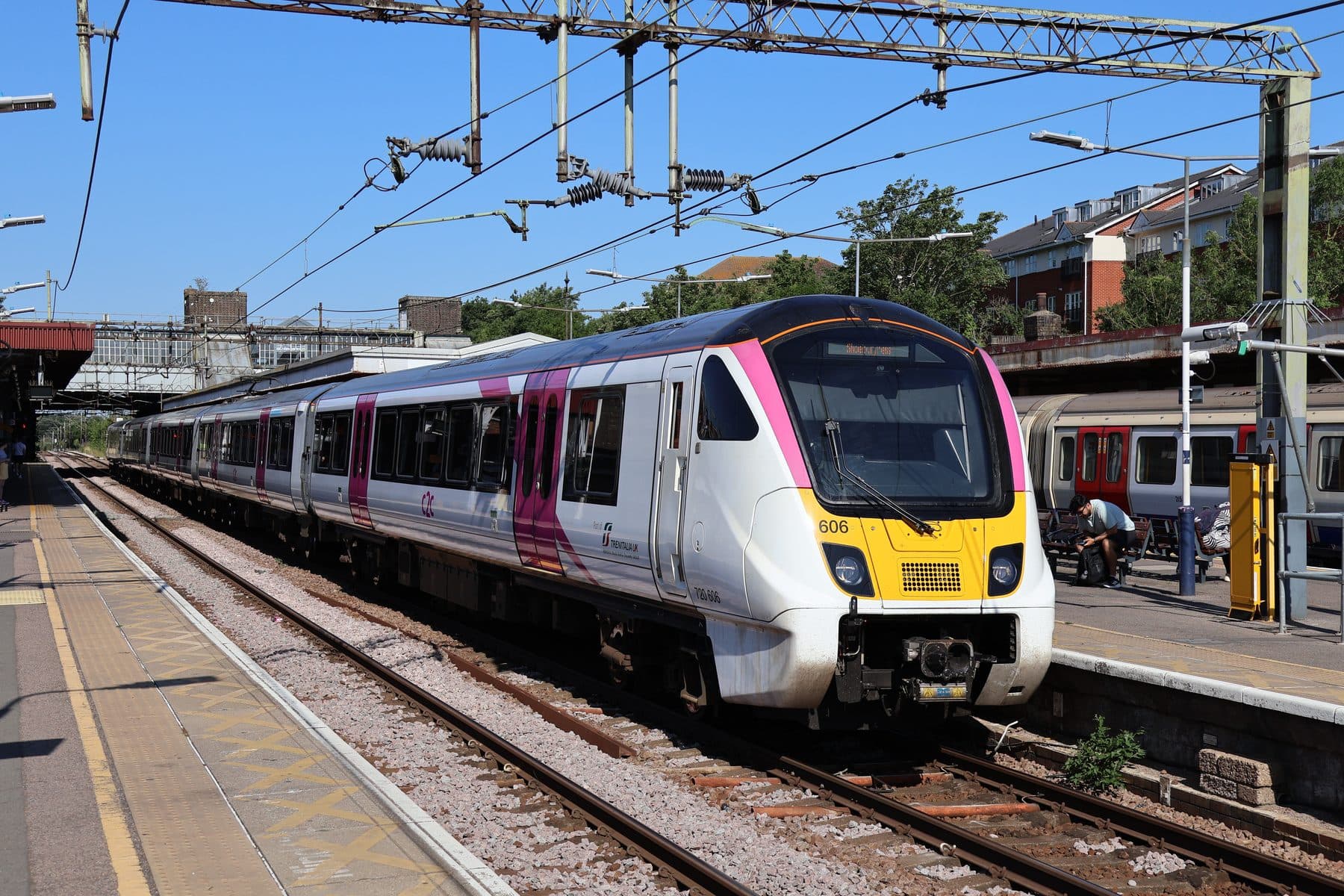 A c2c Class 720 Aventra train in pink and white livery at Upminster station