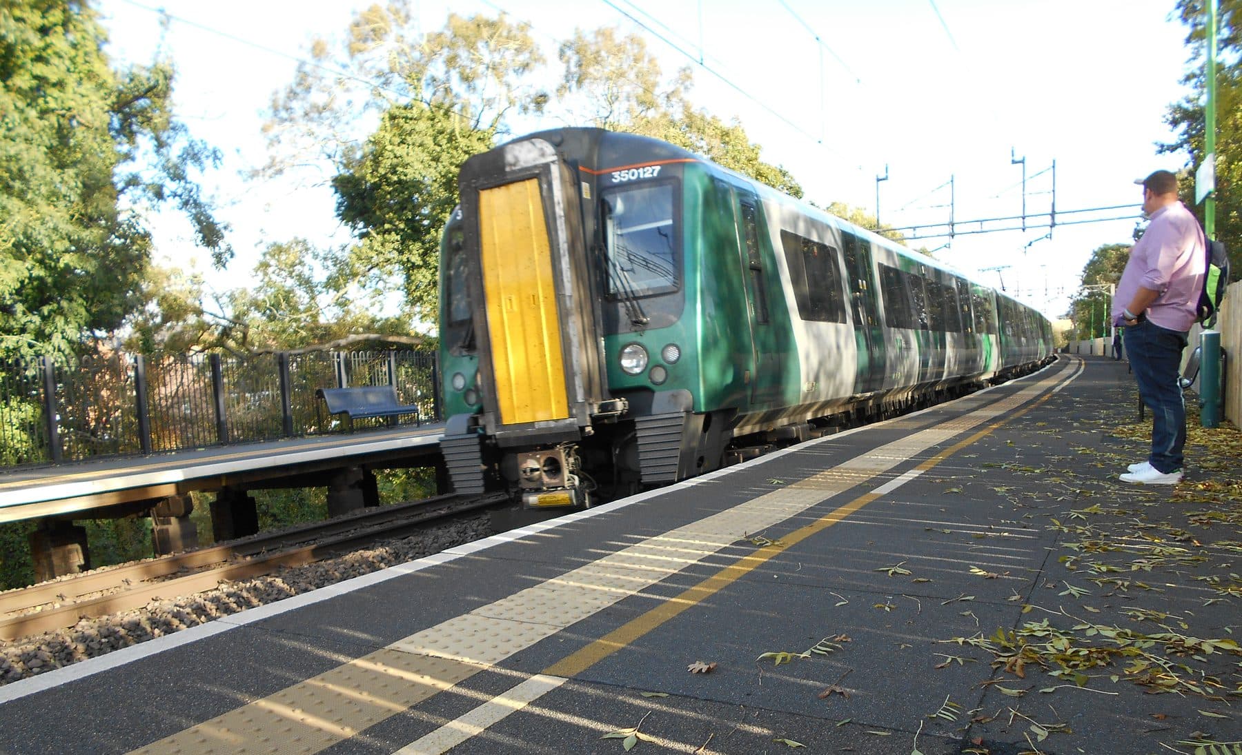 A London Northwestern Railway Class 350 Desiro train in dark green livery pulling into Long Buckby station