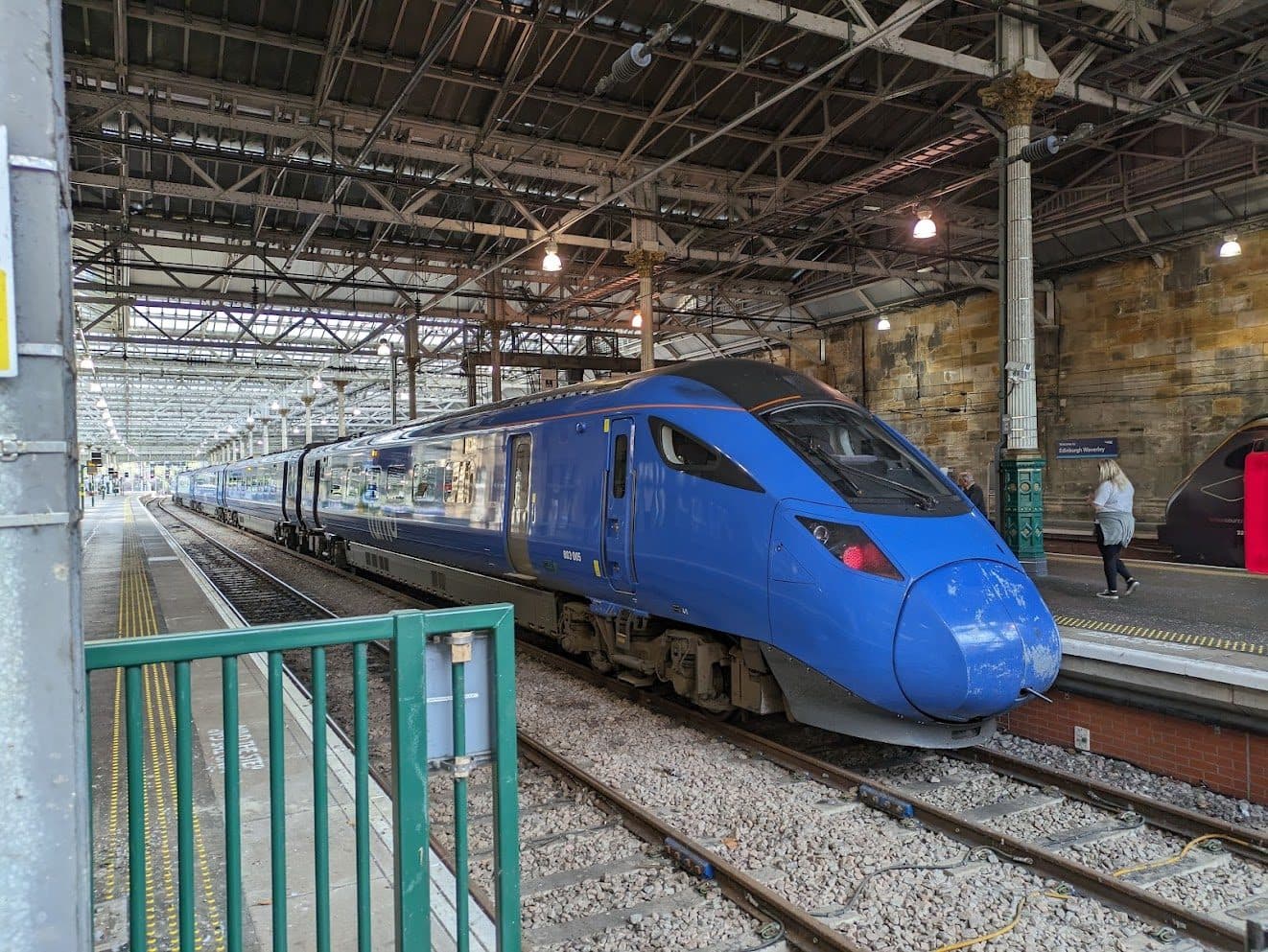 A Lumo Class 803 train in its distinctive bright blue livery at Edinburgh Waverley