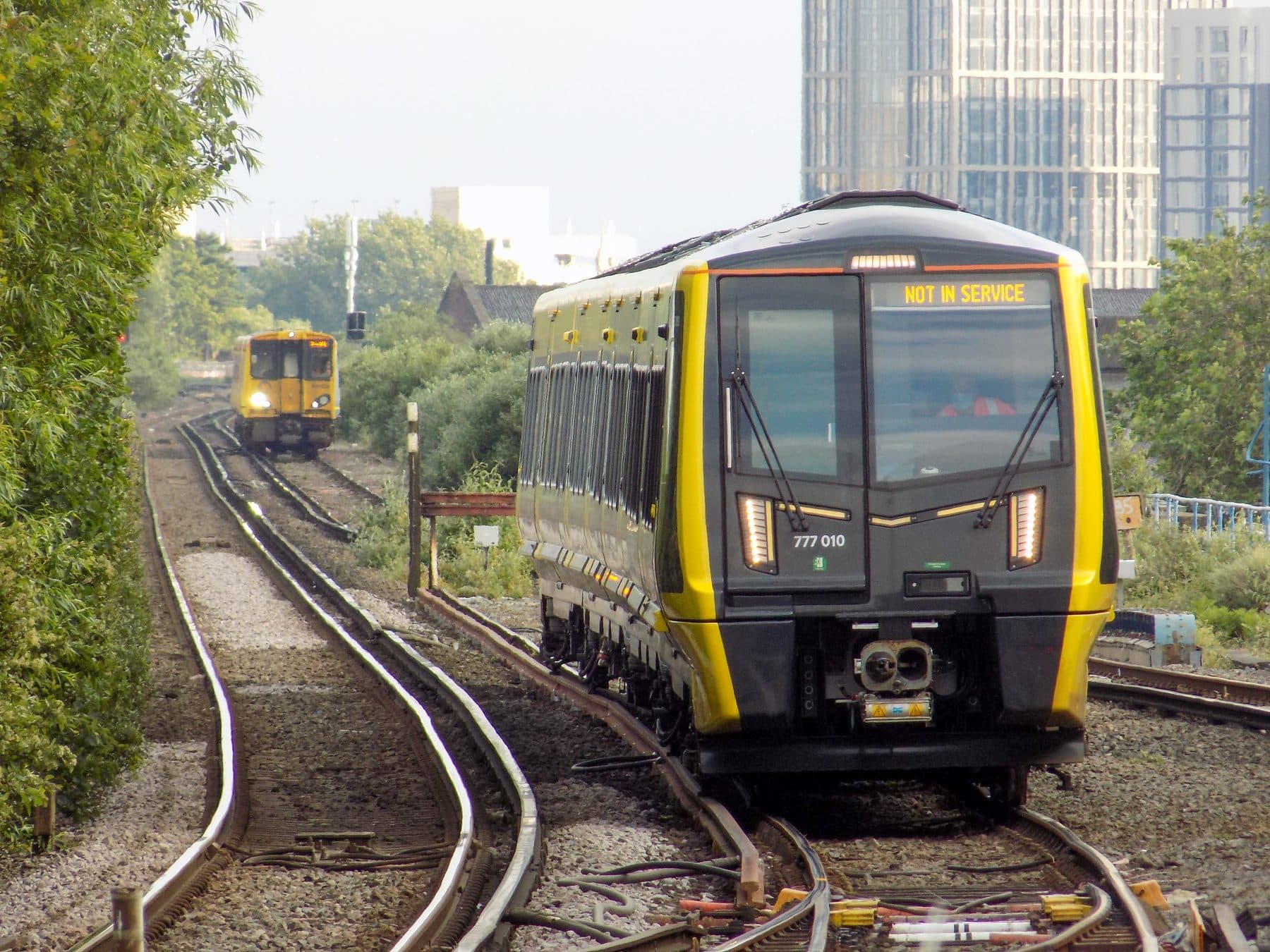 A Merseyrail Class 777 'Metro' train in its yellow and black livery near Sandhills