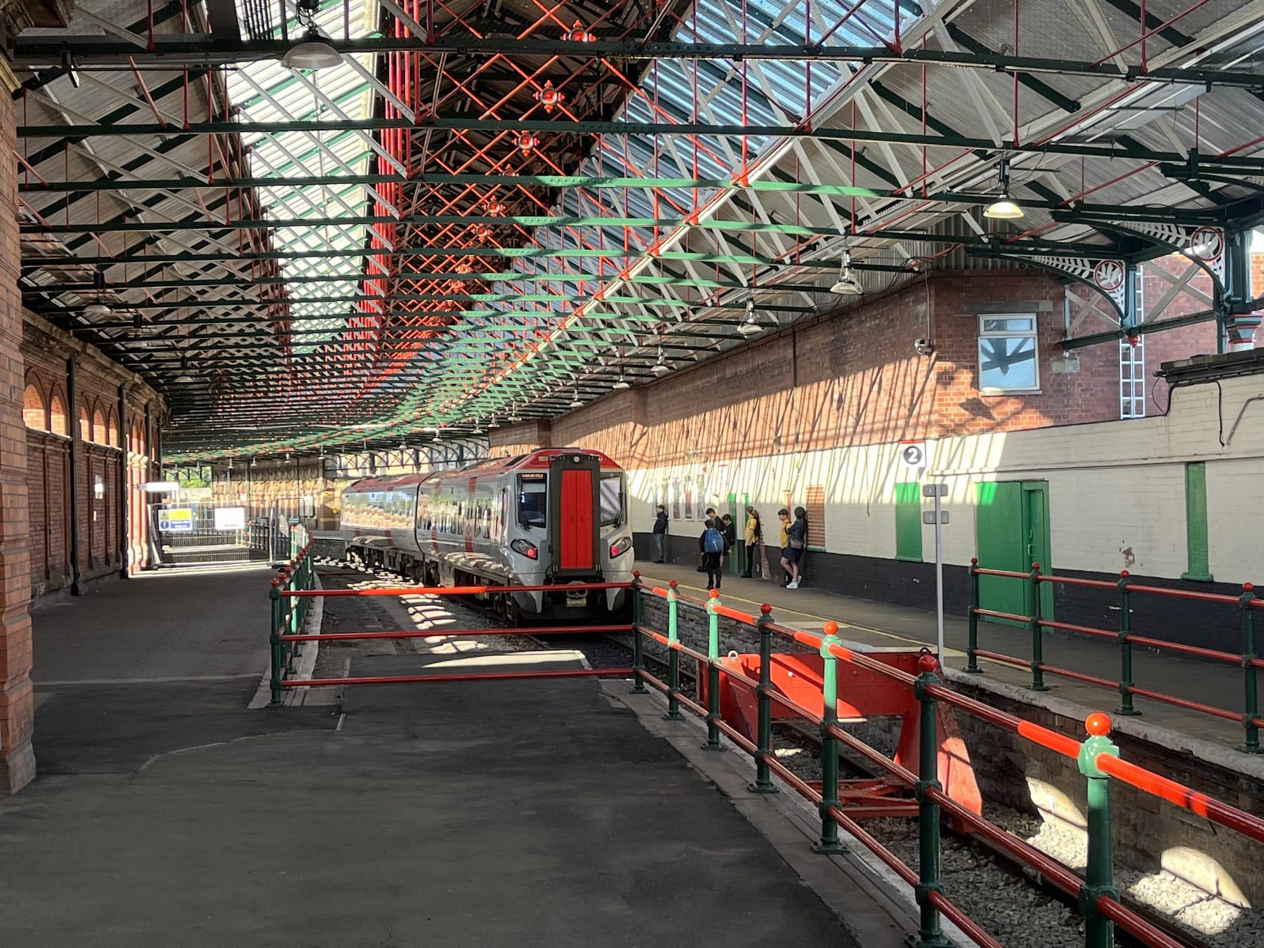 A Transport for Wales Class 197 CAF Civity train in its red and black livery at Holyhead