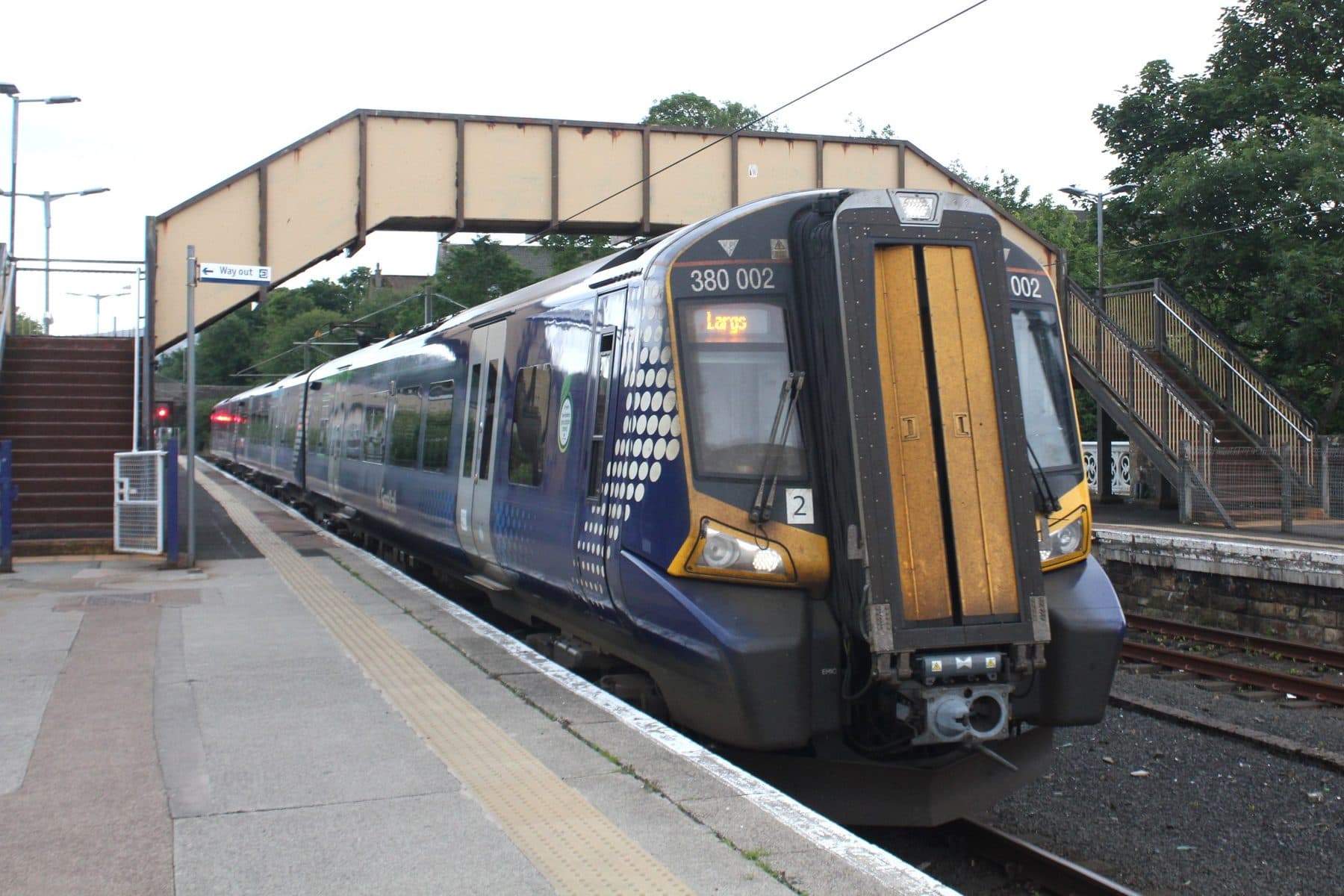 A ScotRail Class 380 train in dark blue Saltire livery arriving at Largs station